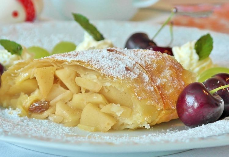 Delicious apple strudel with cherries and cream.