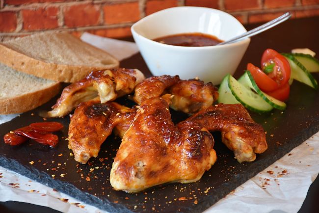 Buffalo chicken wings ready for being used to make a sandwich with tomatoes and salad