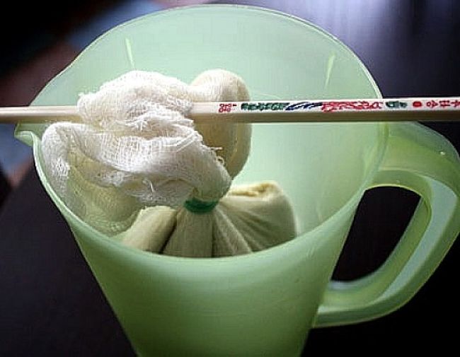 The blended cashew cream is enclosed in a cloth and hung in a bowl to drain and thicken