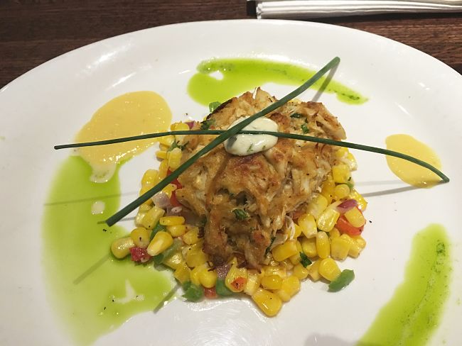 Crab cakes pair well with fresh vegetables and herbs