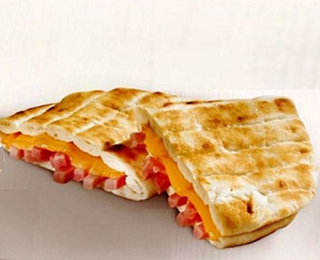 Flatbread filled with ham, cheese and fresh hebs - see more recipes in this article