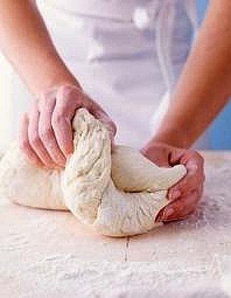 Working the dough after the initial rise ensures the pizza dough is soft and has a uniform texture