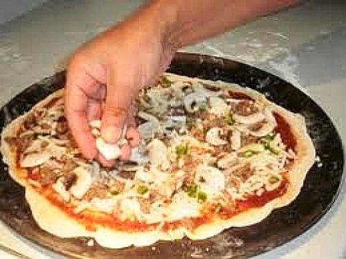 Adding the filling to the homemade pizza - see the range of options in this article