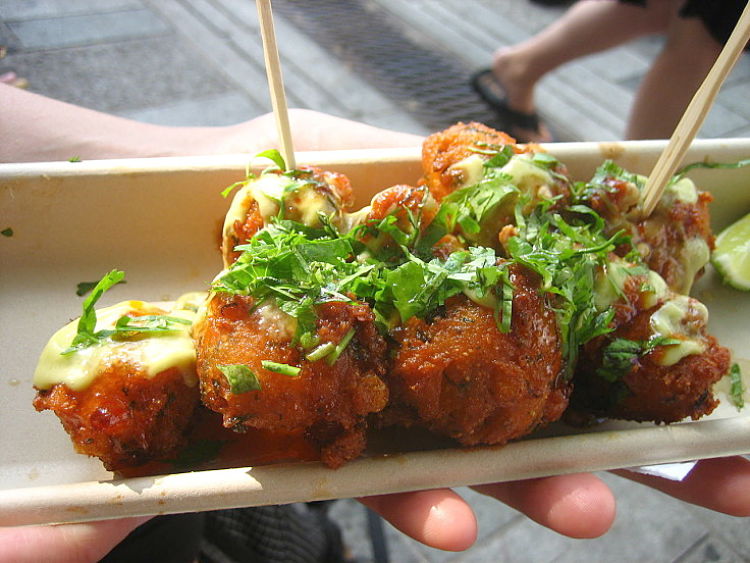 Hush puppies can be served with a variety of sauces and toppings. Wooden sticks makes them easier to eat when hot