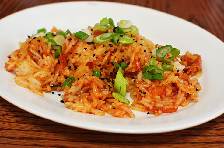 Adding toasted sesame seeds, fresh herbs, sliced chilli and other garnishes adds flavor to homemade Kimchi fried rice