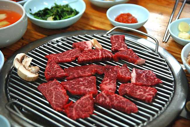 Typical charcoal Korean barbecue setup up where the hot coal are added to the unit set in a table at the restaurant. Learn how to do this at home