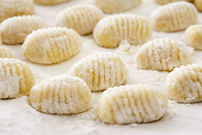 The shaped gnocchi, tossed in flour, ready to cook