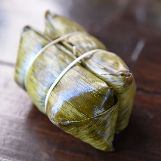 This traditional Thai dessert is made by wrapping sweet banana and sticky rice inside a banana leaf and steaming 